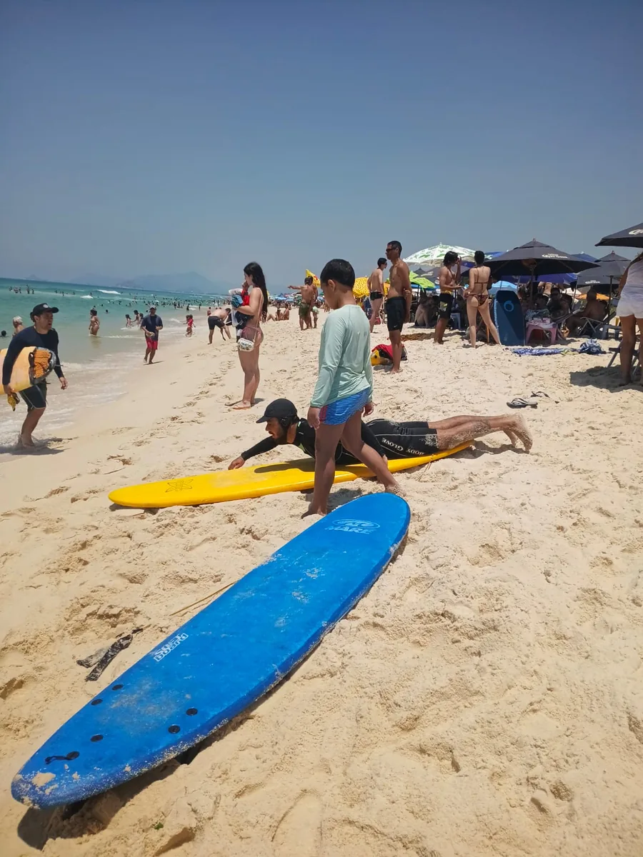 Pranchas de surf na areia da Praia da Reserva com alunos e instrutor